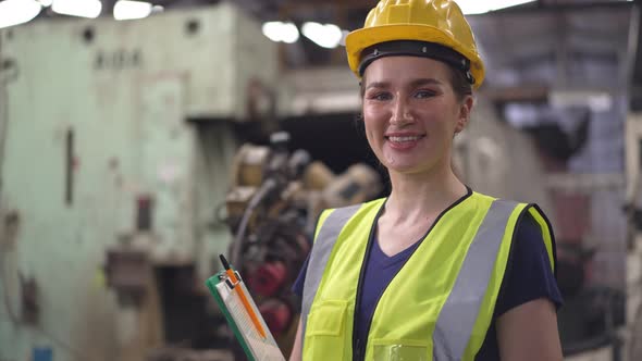 Portrait of female engineer or factory worker holding maintenance checklist