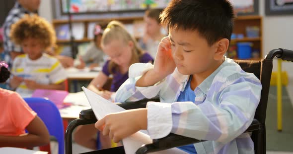Front view of Disabled Asian schoolboy studying in the classroom 4k alt