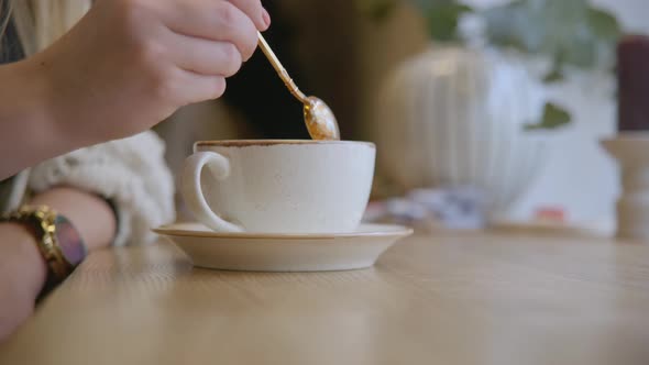 Stirring Coffee With A Golden Spoon