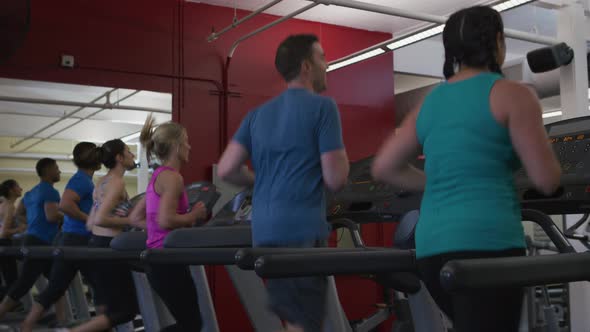 People running on treadmills at gym