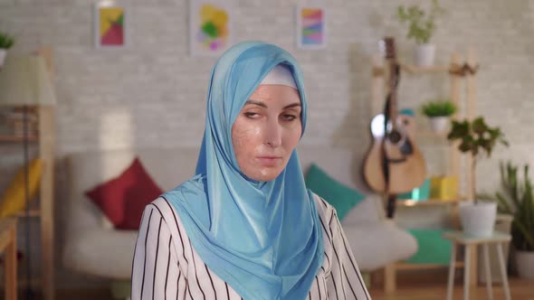 Young Muslim Woman in Hijab with a Burn Scar on Her Face Looking at the Camera alt