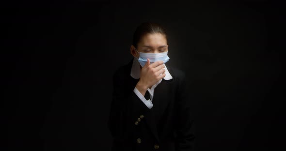 Asian Woman in Business Clothes and a Medical Mask Coughs