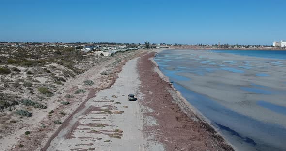 Following a car as it drives along North Beach in Wallaroo South Australia alt
