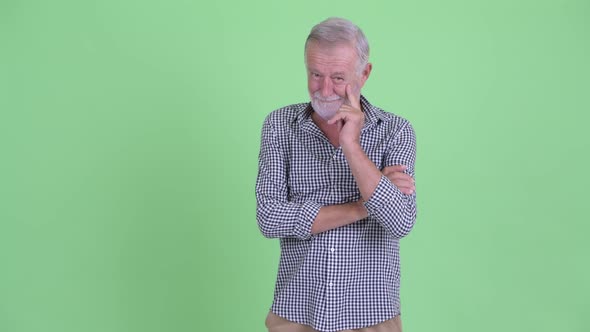 Happy Senior Bearded Man Thinking and Looking Up alt
