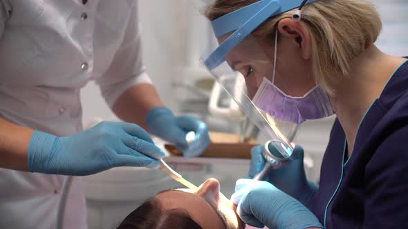 Female Dentist at Work with Assistant