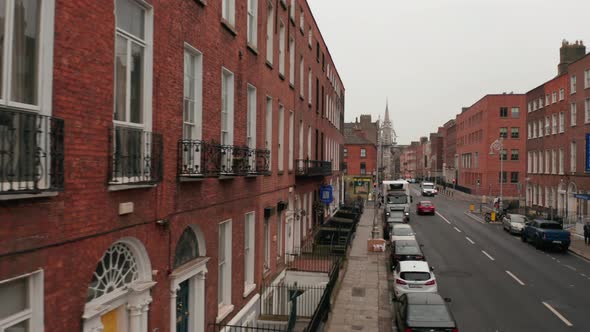 Slider From Brick House Wall to Centre of Narrow Street with Church at End alt