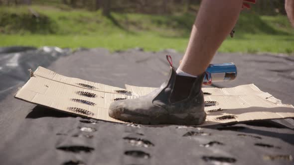 AGRICULTURE - Farmer uses a blow torch to mark divisions for planting garlic alt