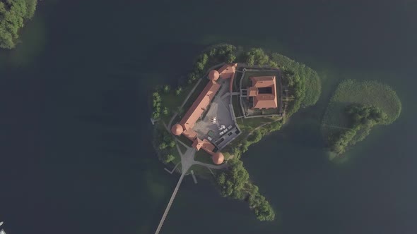 Trakai castle on green island in Galve lake at sunrise, Lithuania, Aerial spinning  zoom out view