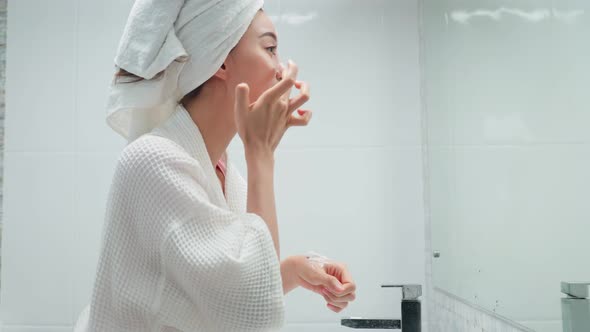 Asian beautiful woman putting smooth and skin care for for facial soft. alt