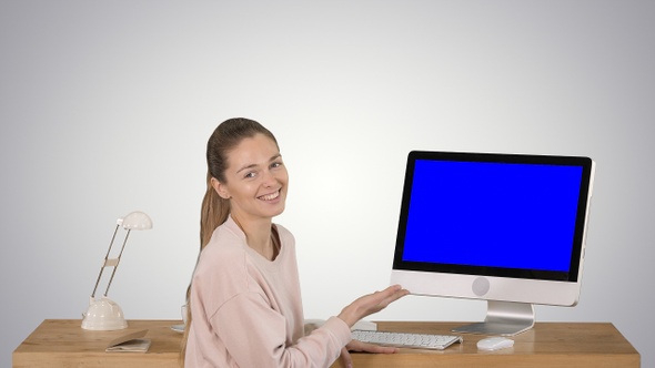 Charming woman presenting something on the screen of computer alt
