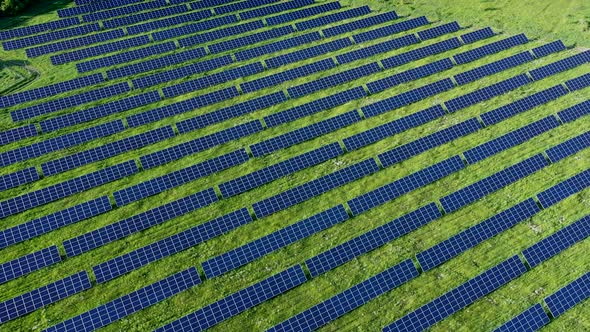 Aerial view on Solar Power Station in Green Field near River at Sunny Day. Fly over Solar Farm alt