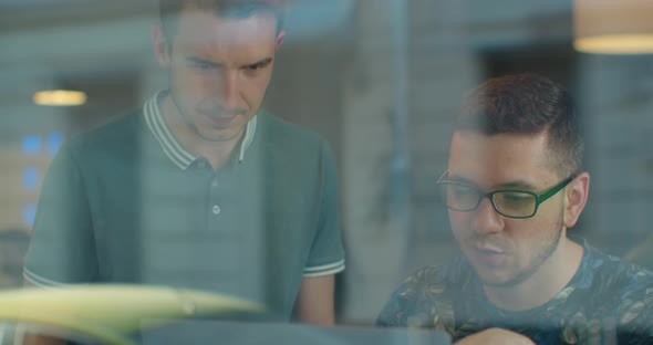 Two Professional IT Programers Discussing Technical Data Show on Computer Display