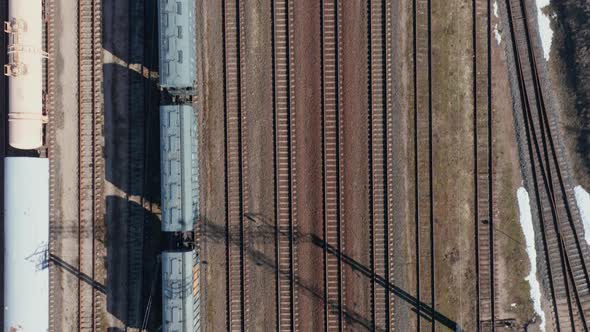 AERIAL: Top Down View of Empty Cargo Train Parked on Train Rails