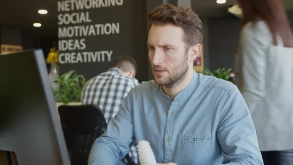 Serious Engineer Examining Detail and Using Computer