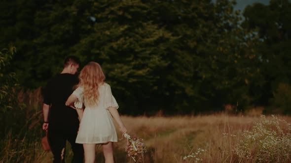 Carefree Young Couple Walking and Smiling on Holiday on Countryside  Freedom and Happiness Concept alt