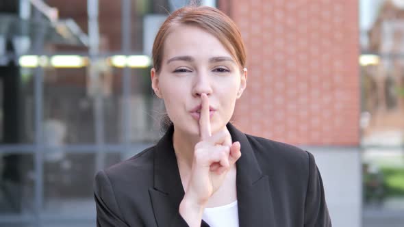 Silence Please, Finger on Lips by Young Businesswoman alt