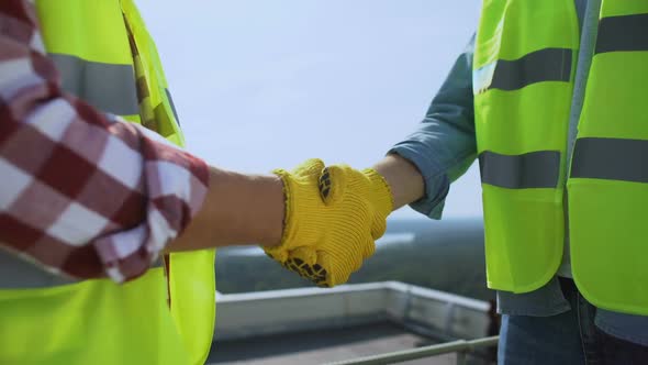 Male Workers in Safety Jackets and Gloves Shaking Hand, Partnership Agreement