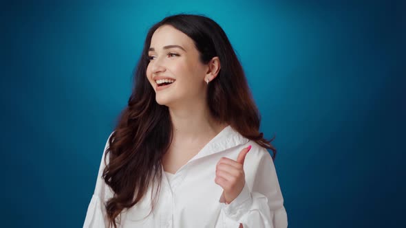 Cheerful Young Woman Smiling and Laughing Against Blue Background