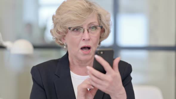 Portrait of Old Businesswoman Having Loss on Smartphone alt