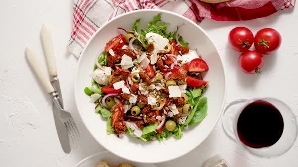 Tasty Dried Tomatoes Salad with Fresh Vegetables Mix and Mozzarella Cheese Served with Toasts