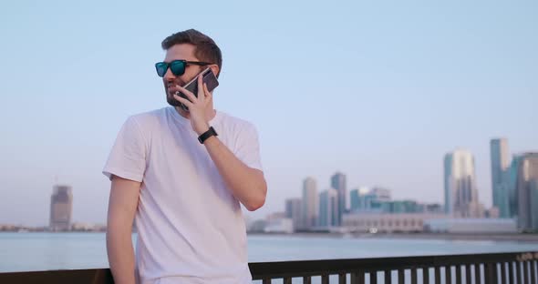 A Man in Summer Sunglasses Talking on the Phone  alt