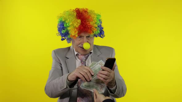 Senior Clown Businessman Entrepreneur Loses Money While Working on Phone Online alt