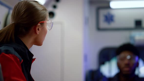 Medical Worker Driving in Ambulance Car alt