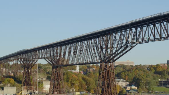 Low angle view of walkway over Hudson river, trees and settlement at distance alt