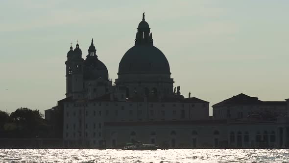 Silhouette of Cathedral Across Glittering Ruffled River, Boat Going Down Canal