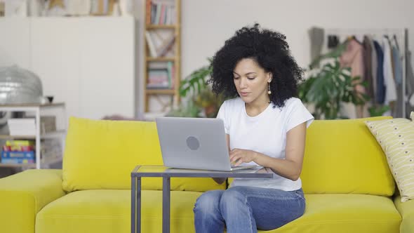 Portrait of a Young African American Woman Typing on Laptop Keyboard alt