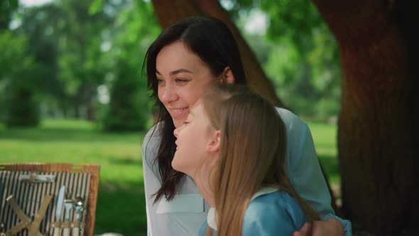 Mother Laughing with Daughter on Picnic Closeup alt