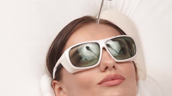 Close-up of Laser Theraphy on Woman Forehead alt