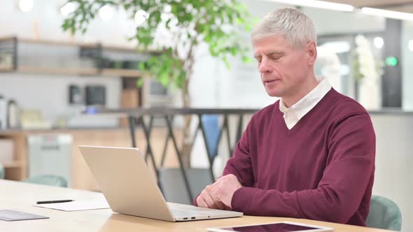 Serious Middle Aged Man with Laptop Looking at the Camera alt