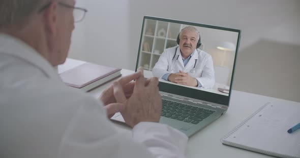 Therapist and Surgeon Are Communicating and Consulting By Online Video Conference at Laptop alt