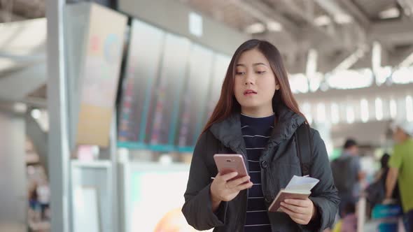 Young traveler female check in with smartphone at airport