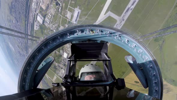 Su-35 Aircraft with a Pilot Spinning in Air Above Field and Performing Maneuvers alt