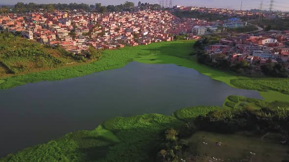 Beautiful aerial view descending over the Sao Paulo favelas and water reserve alt