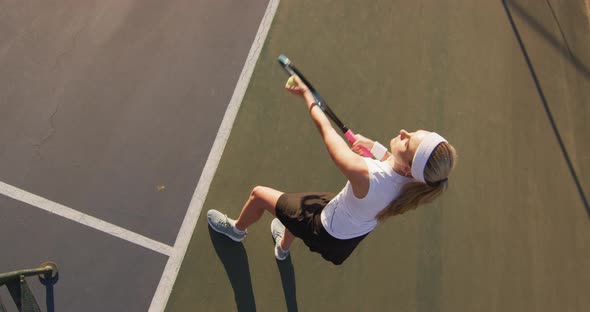 Video of top view of caucasian female tennis player holding racket and hitting ball alt