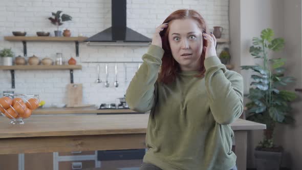 Portrait of Excited Chubby Young Woman Looking at Camera Closing Mouth with Hand alt
