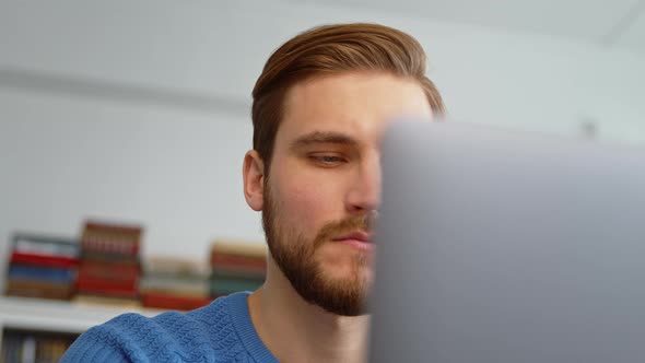 Thoughtful man thinking about online project while looking at laptop alt