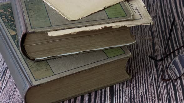 Pile of two old brown books with eye glasses