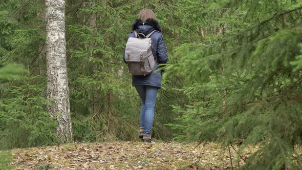 Young Woman With Backpack in a Forest in Summer