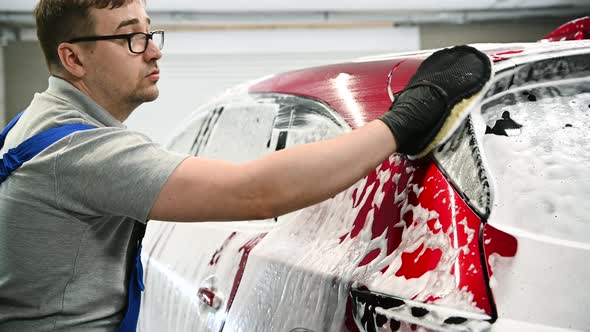 Man Washing a Car Using Hand Glove Wiping Foam alt