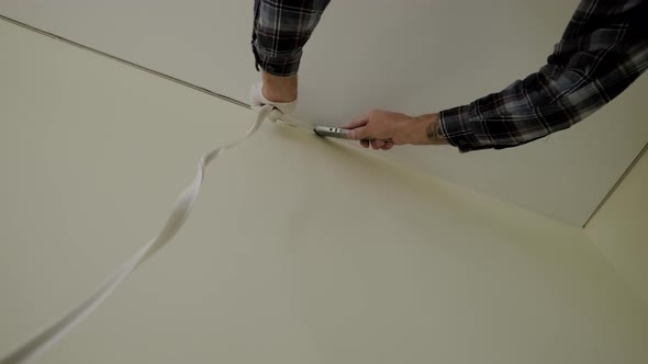Shot of Workers Stretch the Stretch Ceiling in the Room alt