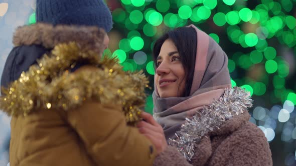 Happy Young Slim Beautiful Mother Enjoying New Year Leisure with Little Son in City Outdoors alt