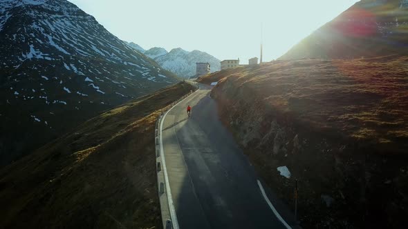 Road Cyclist Climbs Up Sunset Mountain Switchbacks alt