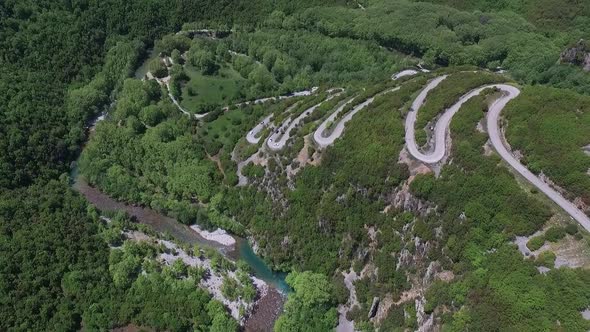 Drone shot. Supercars on a lot of turns heading into the mountain near Paingo, Greece. alt