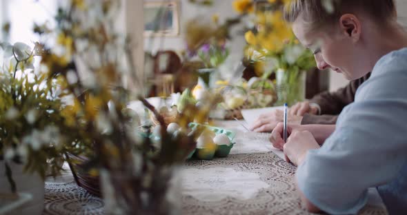 Grandfather and Granddaughter Writing Easter Cards Greetings To Loving Family. alt