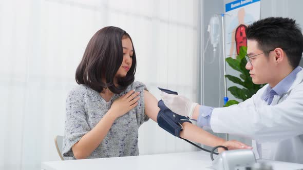 Asian specialist male doctor use blood pressure gauge examine patient. alt
