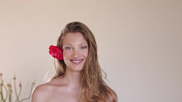 Beautiful woman with red hibuscus flower in her hair alt